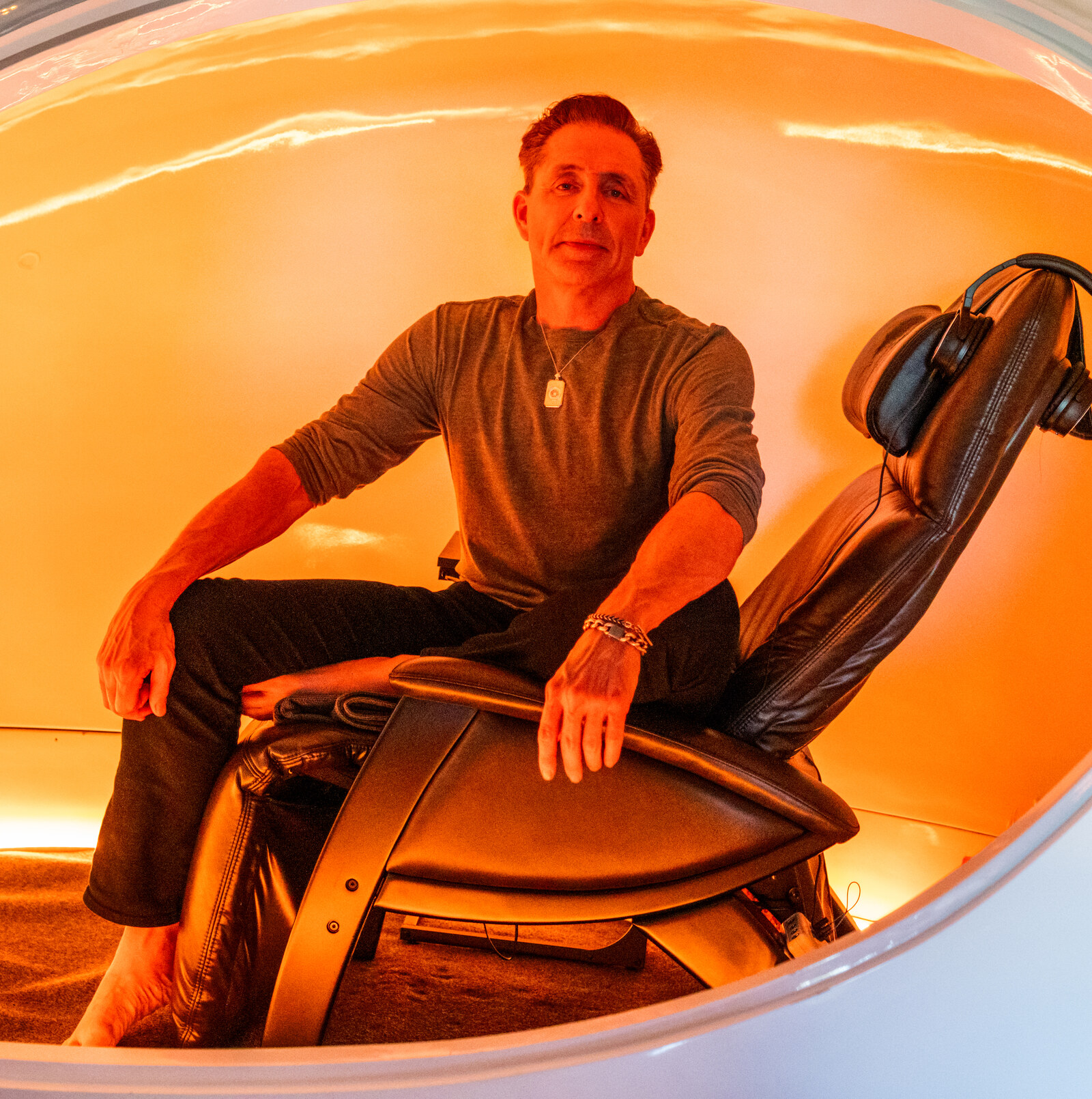 Dave Asprey sitting inside the neurofeedback pod with headphones